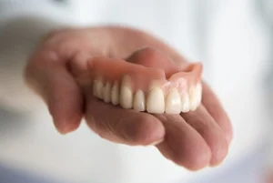 Full Upper Denture on a patient's palm
