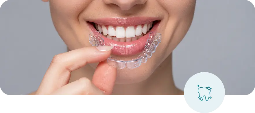 Woman holding clear aligners for teeth straightening