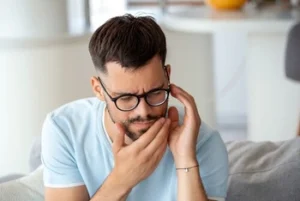 man holding his painful jaw